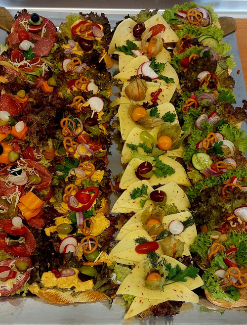 KI generiert: Verschiedene belegte Brötchen auf einem Tablett, garniert mit Gemüse und Käse.