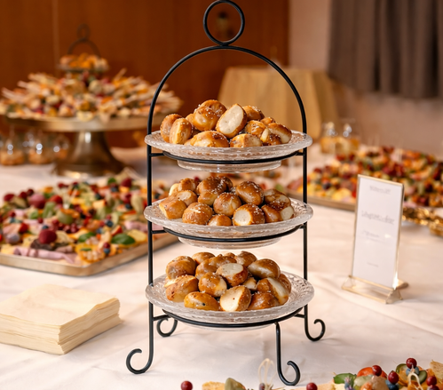 KI generiert: Ein Buffet mit einem dreistöckigen Tablett voller Mini-Brezeln auf einem Tisch.