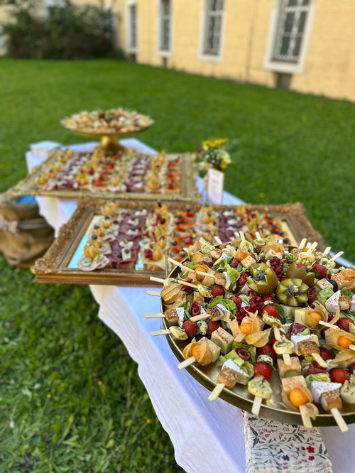 KI generiert: Eine Outdoor-Buffettisch mit dekorativen Vorspeisen auf Spießen und eleganten Tabletts.