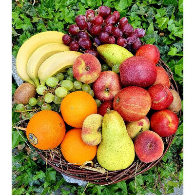 KI generiert: Ein Korb voller bunter Früchte, darunter Bananen, Äpfel, Trauben, Birnen und Orangen.