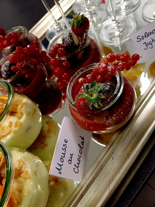 KI generiert: Desserts im Glas auf einem Tablett, beschriftet mit "Mousse au Chocolat".