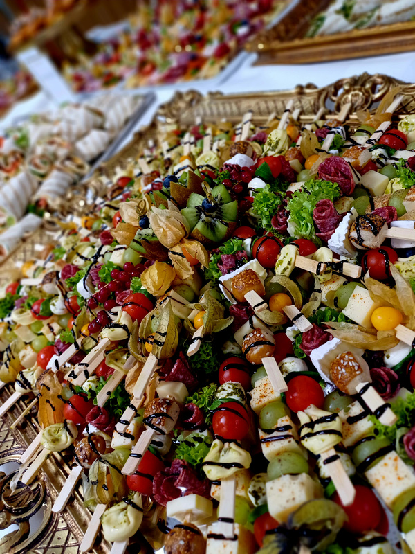 KI generiert: Vielfältige, bunte Vorspeisenplatte mit Frucht- und Käsespießen dekorativ angerichtet.